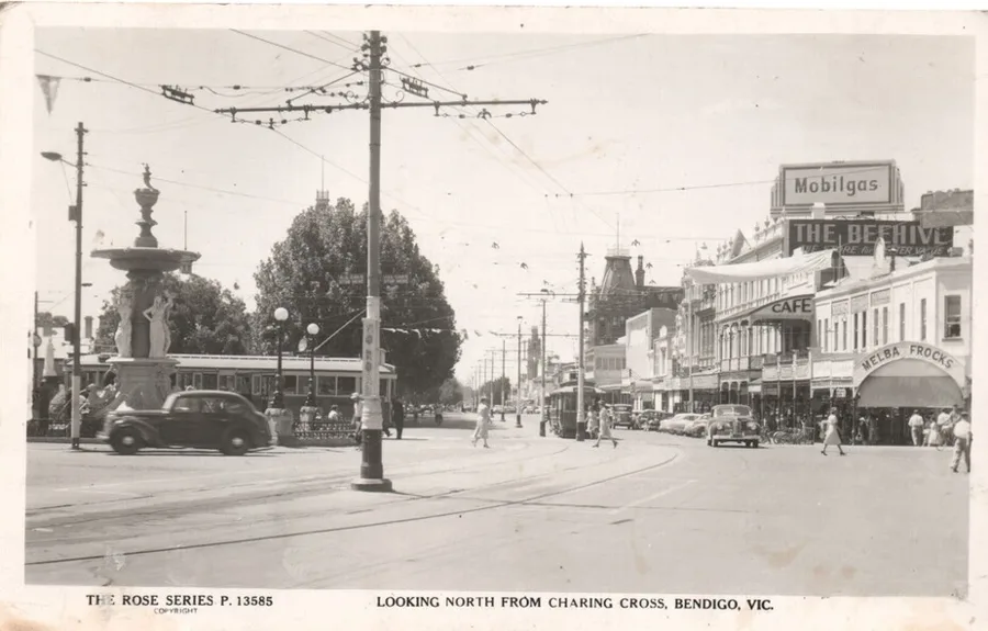 Rose Series postcard P.13585, Looking North from Charing Cross, Bendigo, Victoria, showing the Alexandra Fountain, trams, cars and shopfronts