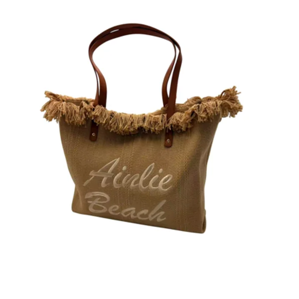 Woven beach tote bag with fringe trim, leather-look handles and Airlie Beach embroidered on the front