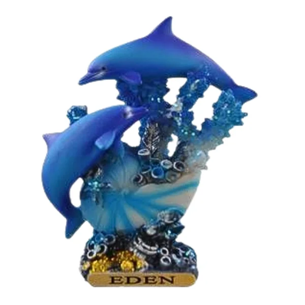 Resin souvenir of two blue dolphins leaping over coral and a shell, on a base labelled Eden