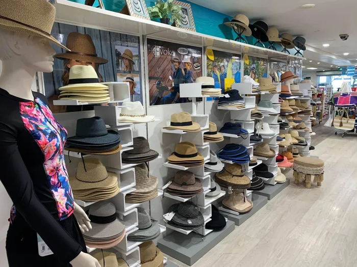 A wall of souvenir hats and caps in a tourist gift shop